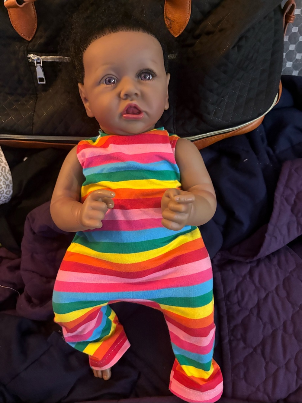 Lifelike baby doll in Rainbow Striped Infant Doll Romper